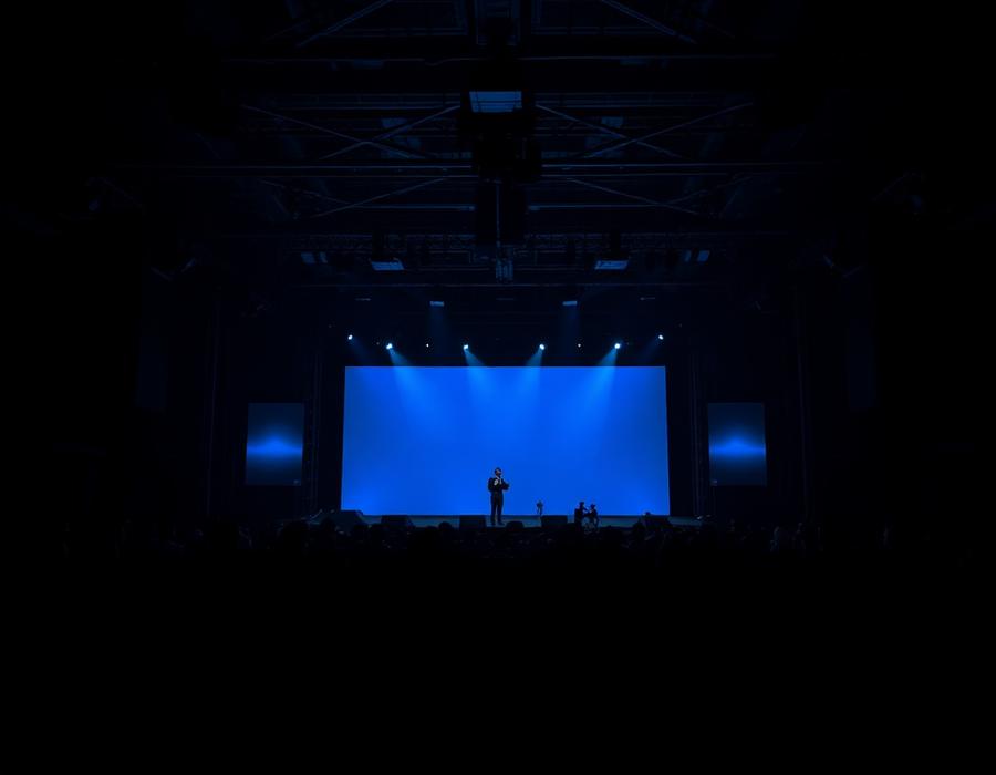 Conference keynote stage lit in blue